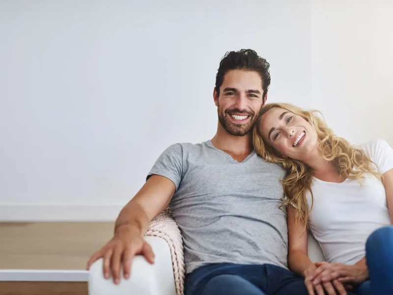 Couple smiling on a sofa
